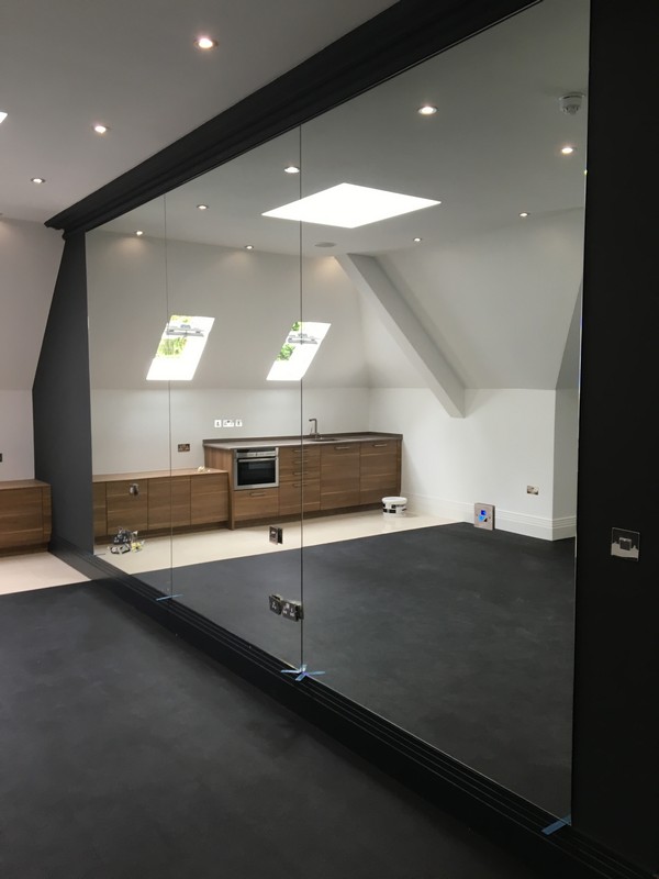 Frameless glass partition in loft conversion by Colindale glaziers