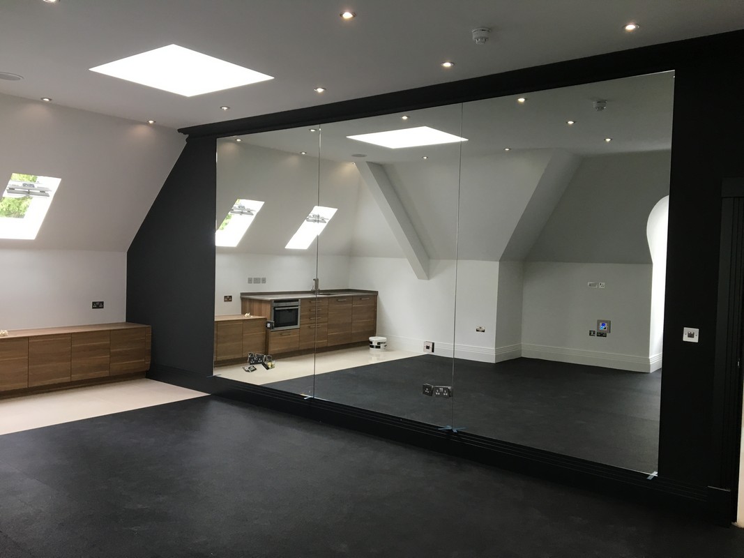 Frameless glass wall dividing loft conversion in Colindale